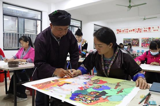 En mayo de 2022, en el Centro Cultural del Condado Autónomo de la Etnia Miao de Rongshui, ciudad de Liuzhou, en Guangxi, Miao Jialin, experto en pintura de los campesinos, enseña a los estudiantes a pintar. (Foto de Liao Ziyuan/Pueblo en Línea)