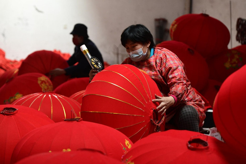 Una trabajadora fabrica faroles en la aldea Tuntou del distrito Gaocheng, en Shijiazhuang, provincia de Hebei. [Foto: Chen Qibao/ China Daily]