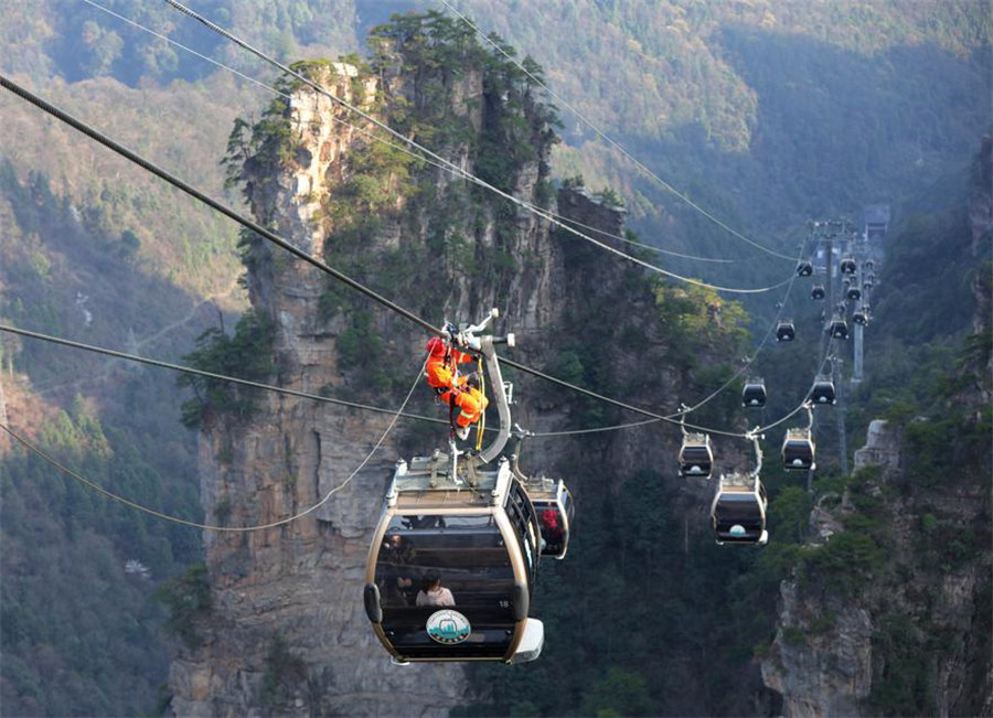 Trabajadores de rescate y mantenimiento del Parque Forestal Nacional de Zhangjiajie en la provincia de Hunan, realizaron recientemente un simulacro de rescate en el teleférico de Tianzishan. [Foto de Wu Yongbing/Para chinadaily.com.cn]