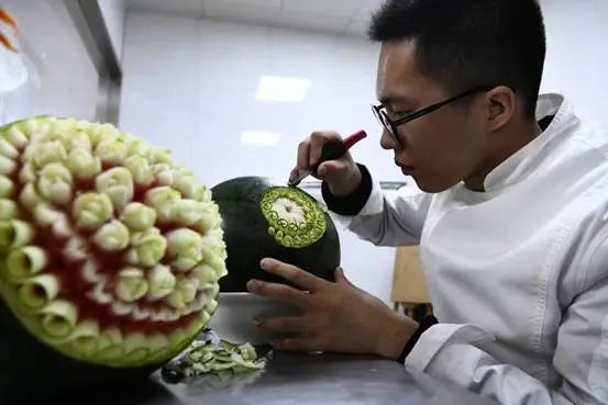 Zheng Yunhai practica el tallado en una sandía. (Foto: Zhejiang Daily Press Group)