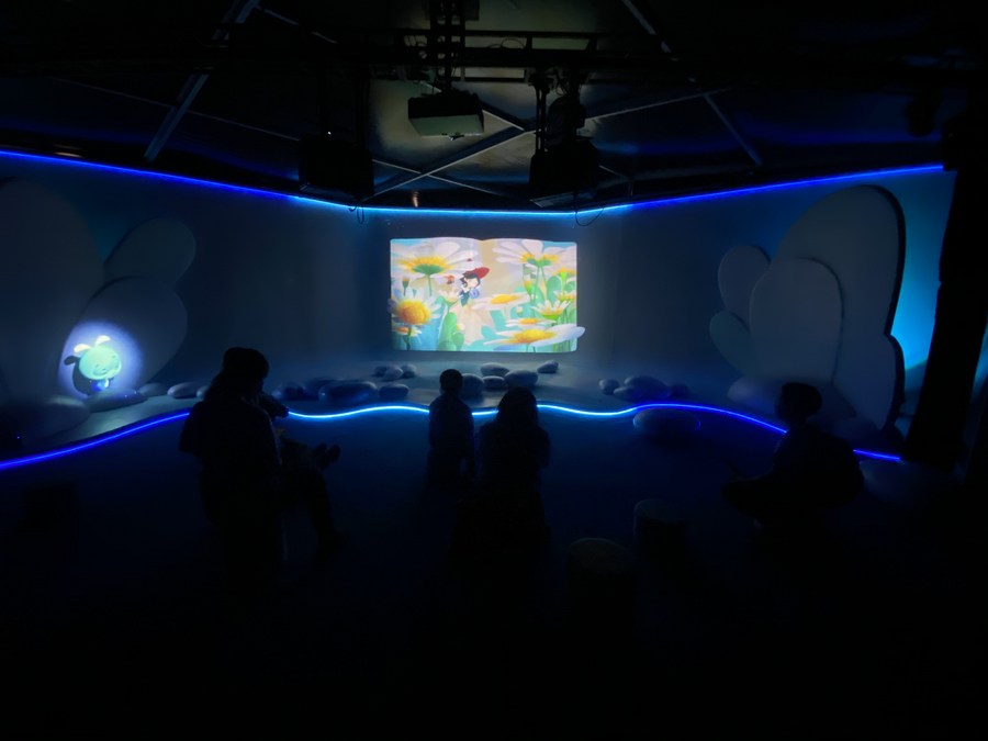 Visitantes recorren una sala en la que se exhiben tecnologías de lectura holográfica para niños, durante la primera Conferencia Nacional de Lectura en Beijing, la capital de China, el 23 de abril de 2022. (Xinhua/Luo Xin)