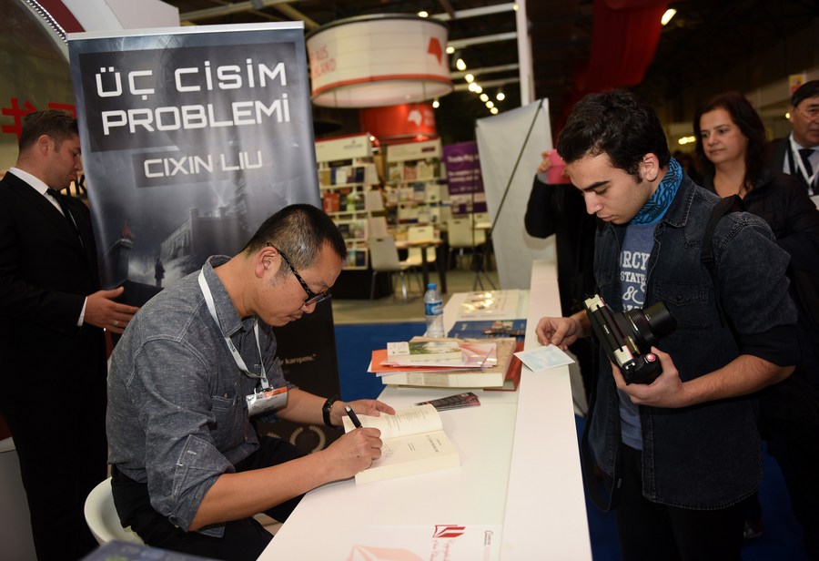 Imagen de archivo del escritor de ciencia ficción chino Liu Cixin (i), firmando la versión en turco de su trabajo "El Problema de Tres Cuerpos", durante la Feria del Libro de Estambul 2015, en Estambul, Turquía, el 7 de noviembre de 2015. (Xinhua/He Canling)