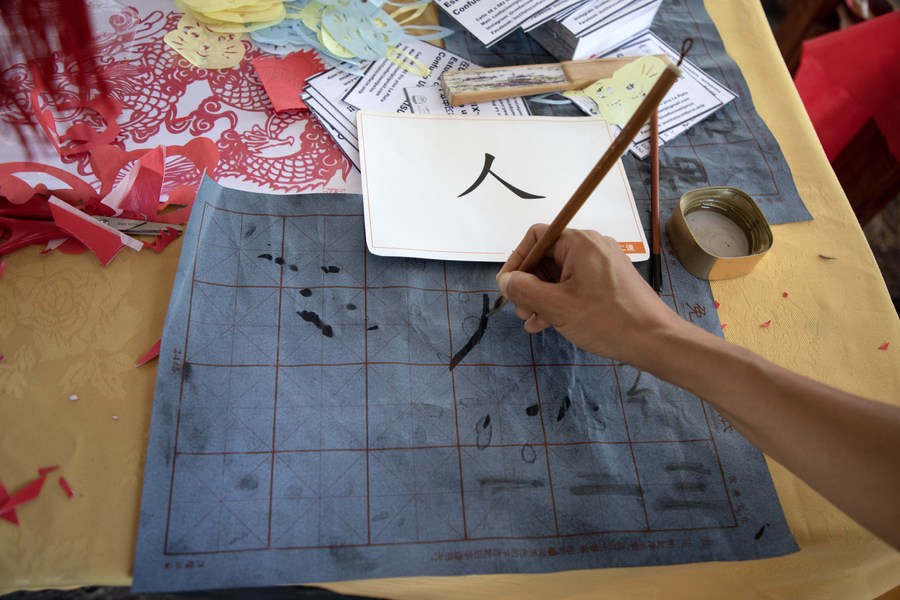 Imagen del 11 de marzo de 2023 de una persona practicando caligrafía china en un estand durante un festival de la cultura china en el Paseo del Bosque, en la ciudad de La Plata, Argentina. (Xinhua/Martín Zabala)