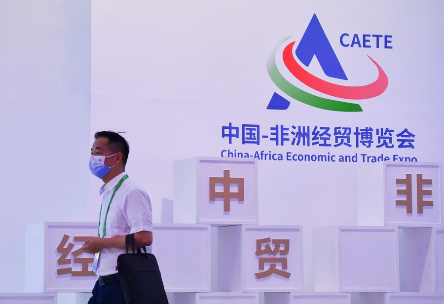 Un empleado pasa frente al logo de la segunda Exposición Económica y Comercial China-África, en Changsha, capital de la provincia central china de Hunan, el 26 de septiembre de 2021. (Xinhua/Chen Zeguo)