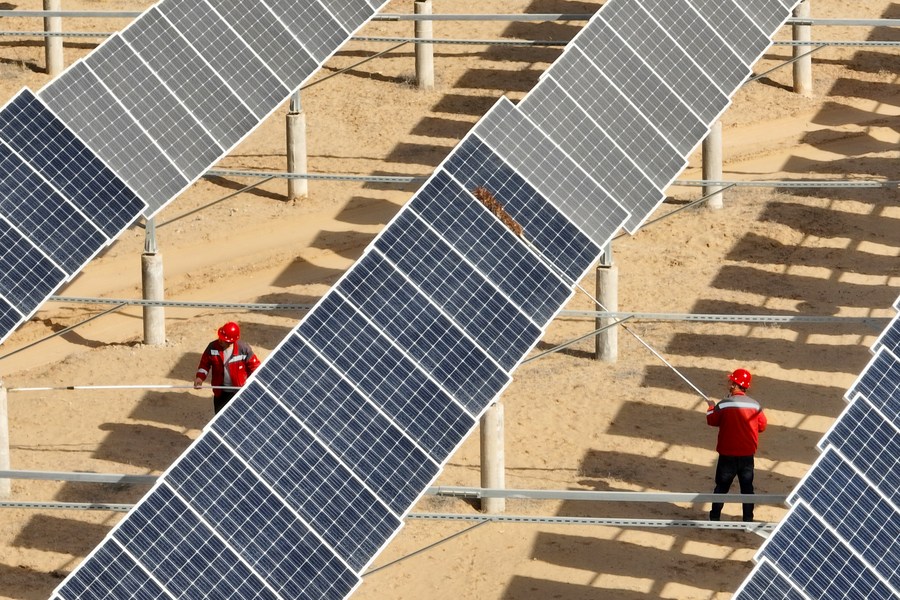 Trabajadores limpian el polvo de paneles solares después de una oleada de vientos en una estación de energía fotovoltaica en Yinchuan, capital de la región autónoma de la etnia hui de Ningxia, en el noroeste de China, el 25 de marzo de 2023. (Xinhua/Wang Peng)