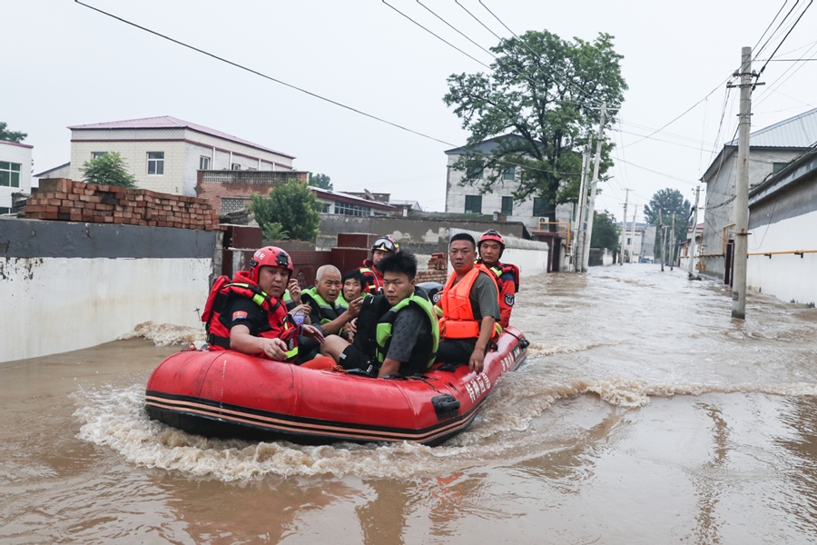 Los rescatistas trasladan a personas atrapadas por las inundaciones en Zhuozhou, provincia de Hebei, 2 de agosto del 2023. [Foto: Wang Jing / chinadaily.com.cn]