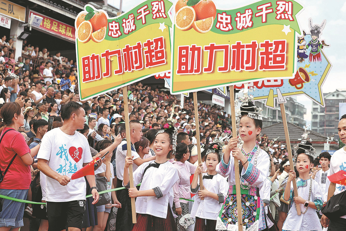 Niños vestidos con trajes tradicionales de grupos étnicos animan durante un juego de la "Super Liga de Aldeas", 28 de julio del 2023. (Foto: Zhu Xingxin/ China Daily)