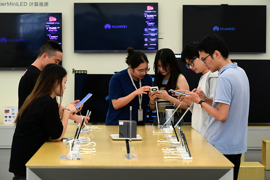 Compradores prueban los teléfonos inteligentes Mate 60 Pro de Huawei en una tienda de Jinhua, provincia de Zhejiang. (Foto: Shi Bufa/ China Daily)