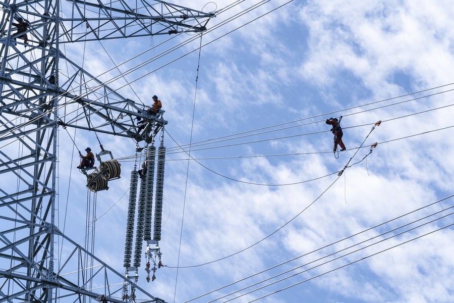 Trabajadores realizan labores en una torre de transmisión de energía en la aldea de Yaodong de Xi'an, en la provincia noroccidental china de Shaanxi, el 29 de septiembre de 2023. (Xinhua/Dong Xiwei)
