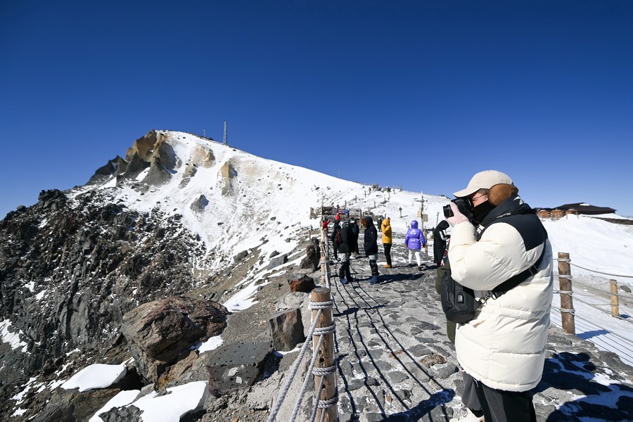 Turistas visitan la montaña Changbai cubierta por la nieve, en la provincia nororiental china de Jilin, el 7 de marzo de 2021. (Xinhua/Yan Linyun)