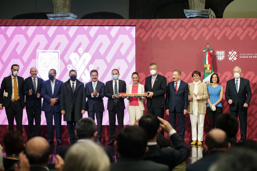 Imagen del 18 de julio de 2022 del embajador de China en México, Zhu Qingqiao (5-d), la jefa de Gobierno de la Ciudad de México, Claudia Sheinbaum (6-d), el secretario de Movilidad de la Ciudad de México, Andrés Lajous (i), y el director del Sistema de Transporte Colectivo-Metro de la Ciudad de México, Guillermo Calderón (2-i), participando durante la ceremonia de banderazo de salida del Primer Tren de Línea de Ensamblaje para La Nueva Línea 1 del Metro de China a México, en la Ciudad de México, capital de México. (Xinhua/Francisco Cañedo)