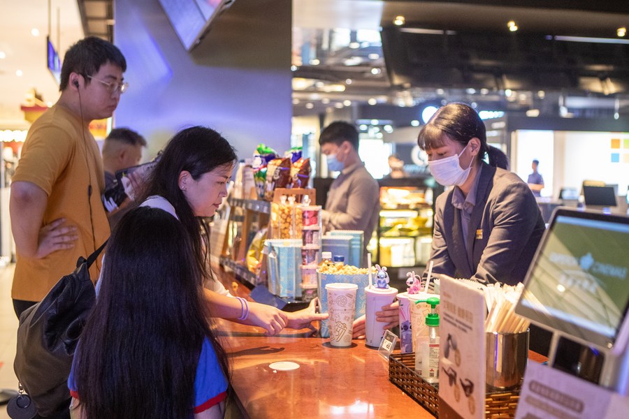 Cinéfilos compran palomitas de maíz y bebidas poco antes del inicio de una proyección en una sala en el distrito de Yubei de Chongqing, municipalidad del suroeste de China, el 30 de julio de 2023. (Xinhua/Chu Jiayin)