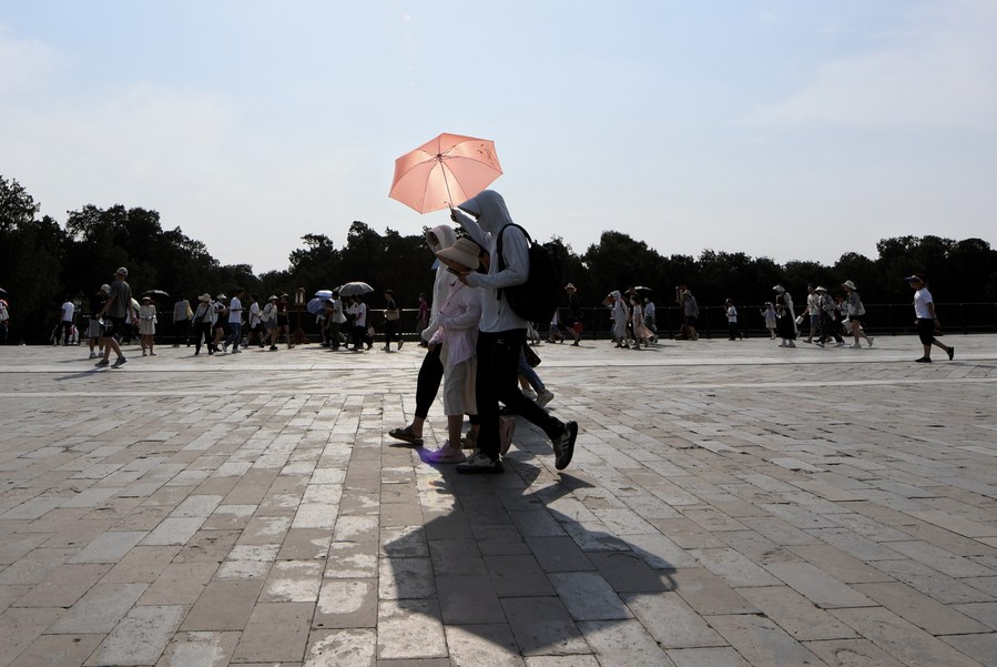 Turistas se protegen del Sol con un paraguas en el Templo del Cielo, en Beijing, capital de China, el 23 de junio de 2023. (Xinhua/Ju Huanzong)