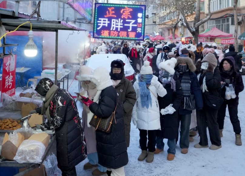 Turistas hacen fila para comprar pasteles fritos en el mercado matutino de la calle Hongzhuan de Harbin, capital de la provincia de Heilongjiang, en el noreste de China, el 22 de enero de 2024. (Xinhua/Wang Yuguo) 