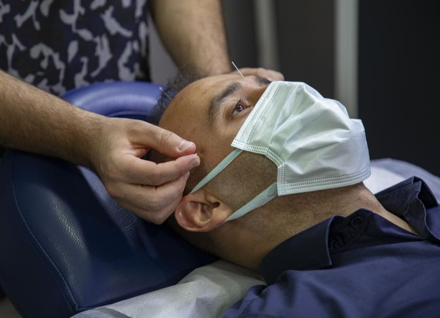 Imagen del 28 de septiembre de 2021 de un hombre recibiendo un tratamiento de acupuntura, en Estambul, Turquía. (Xinhua/Osman Orsal)
