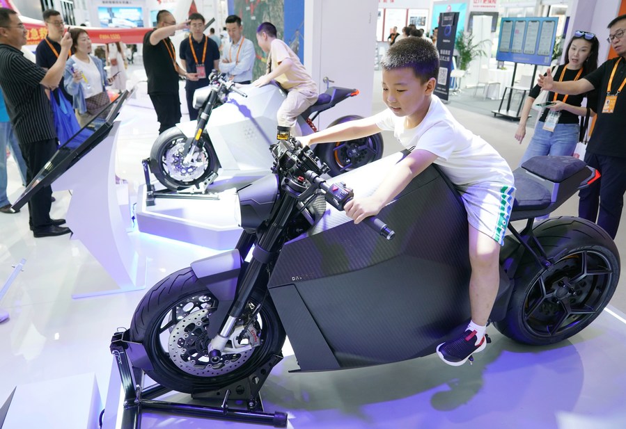 Un niño prueba una motocicleta eléctrica durante la Feria Internacional de Comercio de Servicios de China 2023 (CIFTIS, por sus siglas en inglés) en el Parque Shougang, en Beijing, capital de China, el 3 de septiembre de 2023. (Xinhua/Zhang Chenlin)