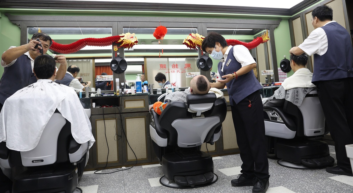 Una peluquera le corta el pelo gratis a un barrendero en Silian Hair Salon en Beijing el 11 de marzo de 2024. [Foto de Zou Hong/chinadaily.com.cn]