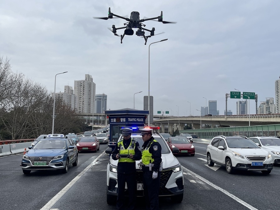 Dos agentes de la policía de tráfico de Shanghái preparan un vehículo aéreo no tripulado para patrullar el tráfico en Shanghái. [Foto cedida a chinadaily.com.cn]