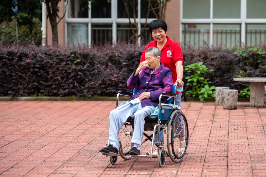 Una integrante del personal cuida a una anciana en silla de ruedas en un centro de bienestar social en el distrito de Hanshou, en la ciudad de Changde, provincia de Hunan, en el centro de China, el 20 de junio de 2023. (Xinhua/Chen Sihan)