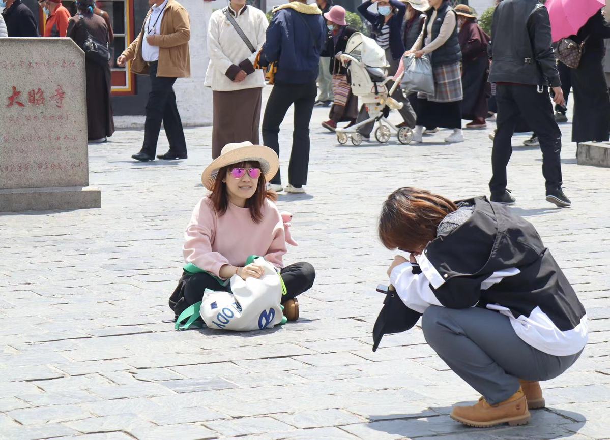 Los turistas posan para fotografías cerca del Templo Jokhang, parte del patrimonio cultural de la UNESCO en Lhasa, región autónoma de Xizang. [Foto de Palden Nyima/chinadaily.com.cn]