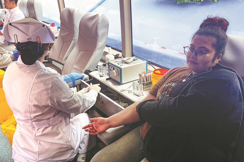 Una expatriada dona sangre en la campaña comunitaria de donación de sangre organizada por Bloodline en Shanghai el sábado. [Foto de Gu Yingjie/China Daily]