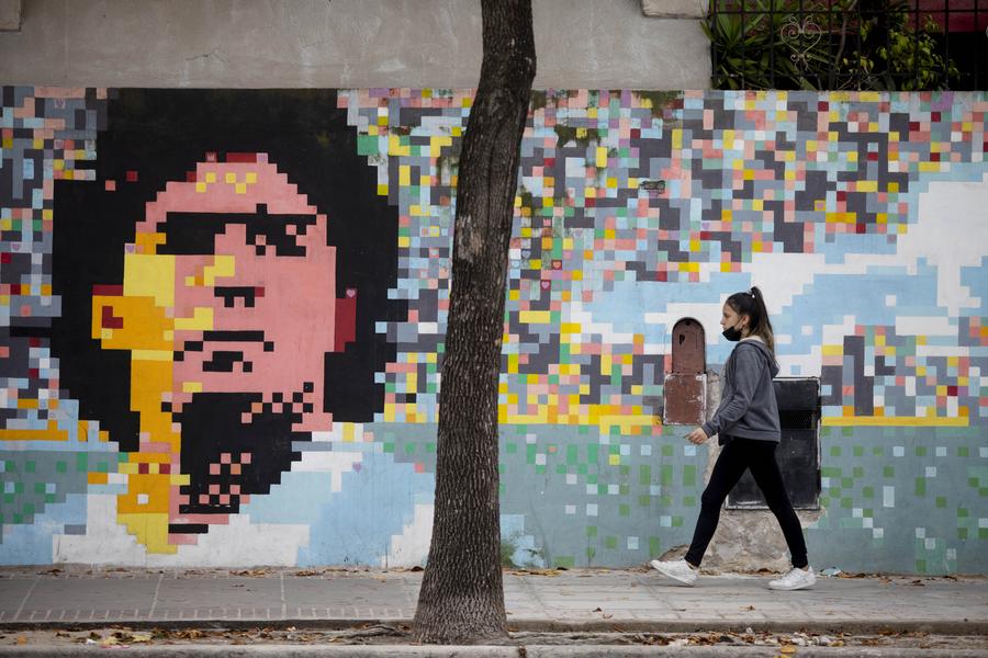 Una mujer camina frente a un mural en homenaje al fallecido ex futbolista argentino, Diego Armando Maradona, en el barrio de San Telmo, en la ciudad de Buenos Aires, Argentina, el 10 de mayo de 2022. (XinhuaMartín Zabala)