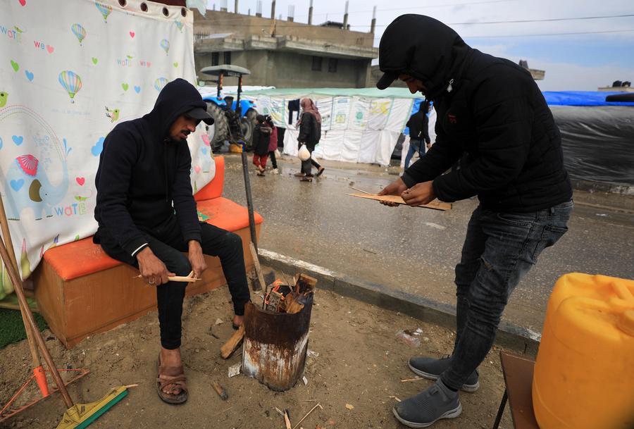  Personas son vistas en una calle durante un día lluvioso, en la ciudad de Rafah, en el sur de la Franja de Gaza, el 2 de febrero de 2024. (Xinhua/Yasser Qudih) 