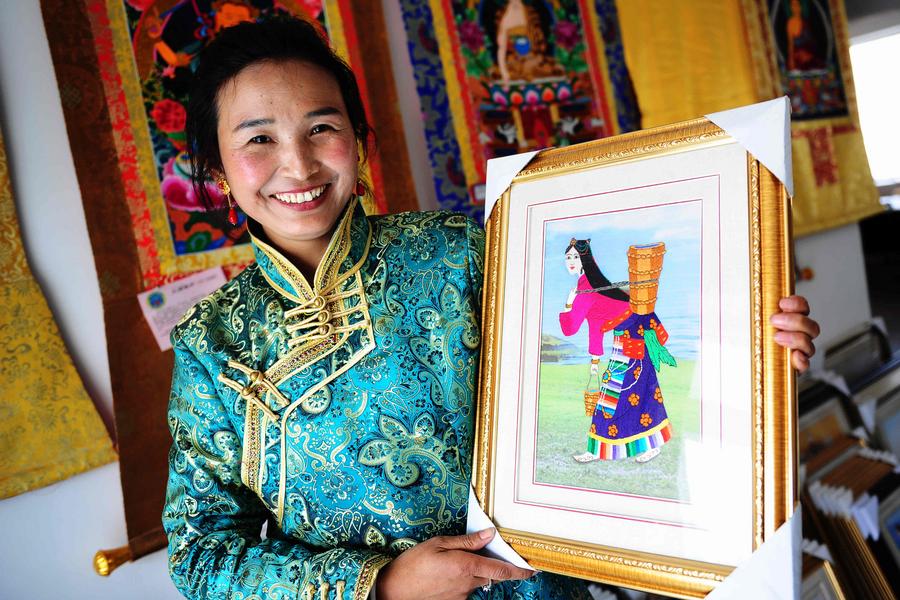 Una mujer muestra su bordado tibetano en un taller en el condado de Guinan de la prefectura autónoma tibetana de Hainan, en la provincia noroccidental china de Qinghai, el 13 de marzo de 2014. (Xinhua/Li Shaopeng)