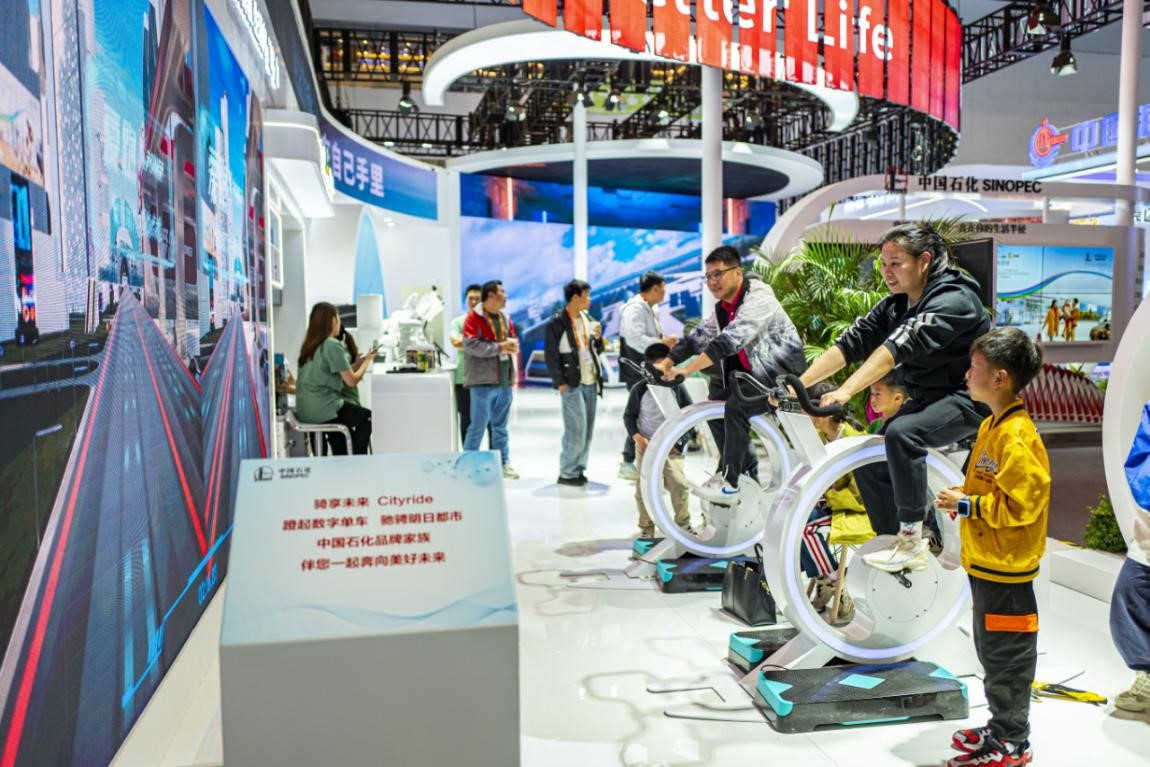 Los visitantes viajan en bicicletas digitales en el stand de Sinopec durante los eventos del Día de la Marca China 2024 en Shanghai, este de China, el 12 de mayo de 2024. (Foto de Wang Chu/Diario del Pueblo digital)