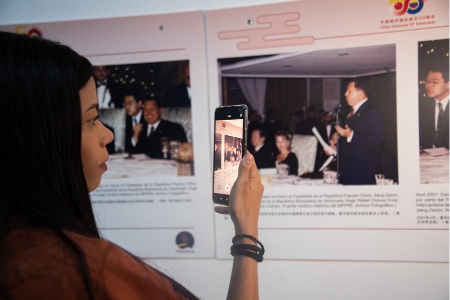 Una mujer toma una fotografía con su teléfono móvil durante la exposición fotográfica "A Toda Prueba y Todo Tiempo" en el marco del 50º Aniversario de las Relaciones Diplomáticas entre China y Venezuela en el Museo de Bellas Artes, en Caracas, Venezuela, el 26 de junio de 2024. (Xinhua/Marcos Salgado) 