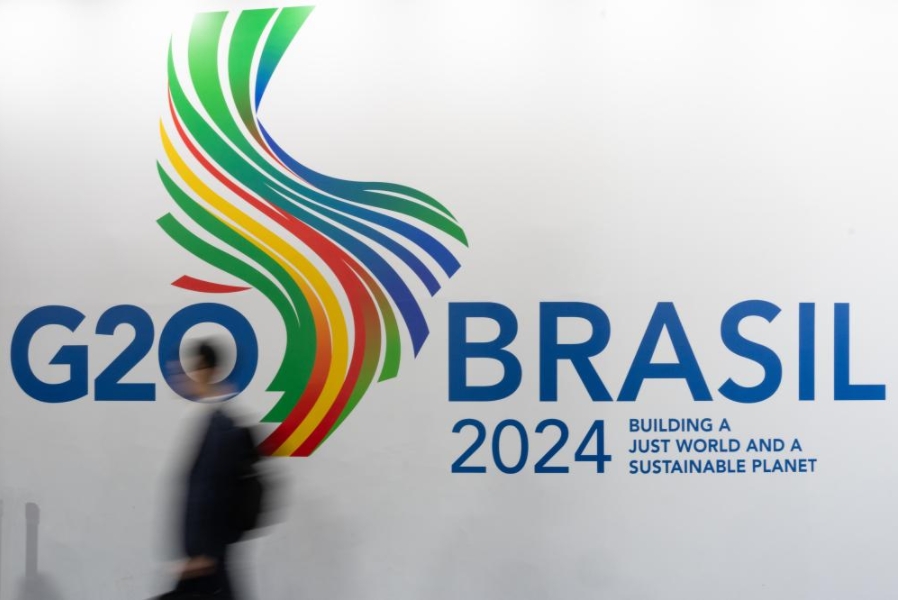 Imagen del 21 de febrero de 2024 de un hombre caminando junto al logotipo del G20 durante la reunión de ministros de Relaciones Exteriores del bloque, en Río de Janeiro, Brasil.(Xinhua/Wang Tiancong)