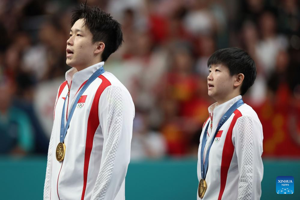 PARIS, 30 julio, 2024 (Xinhua) -- Wang Chuqin (i)/Sun Yingsha de China asisten a la ceremonia de premiación al término del partido por la medalla de oro de dobles mixtos de tenis de mesa entre Wang Chuqin/Sun Yingsha de China y Ri Jong Sik/Kim Kum Yong de la República Popular Democrática de Corea en los Juegos Olímpicos de París 2024, en París, Francia, el 30 de julio de 2024. (Xinhua/Liu Xu)