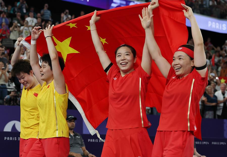 Chen Qingchen (d)/Jia Yifan (2-d) de China y Liu Shengshu (i)/Tan Ning de China sostienen la bandera nacional china al término del partido por la medalla de oro de dobles femeninos de bádminton en los Juegos Olímpicos de París 2024, en París, Francia, el 3 de agosto de 2024. (Xinhua/Chen Bin) 