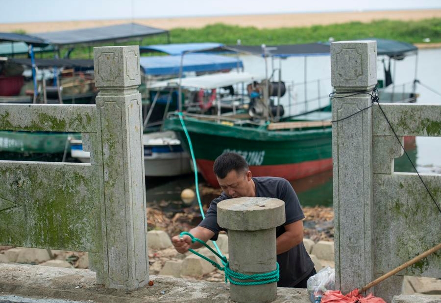 Un pescador sujeta un barco pesquero en el poblado de Boao, de la provincia sureña china de Hainan, el 5 de septiembre de 2024. La Oficina Estatal de Control de Inundaciones y Alivio de Sequías elevó su protocolo de respuesta de emergencia para la prevención de inundaciones y tifones del nivel III al II en las provincias de Guangdong y Hainan a las 15:00 horas del jueves, ante la proximidad del tifón Yagi. (Xinhua/Meng Zhongde)