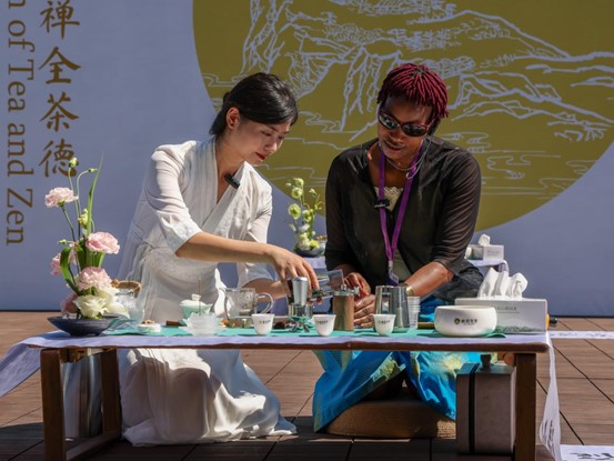 Agnes Mbithe Mwangangi, miembro del grupo conjunto de entrevistas e investigación del Belt and Road Media Co-operation Forum 2024, y el maestro del té Yang Mei intercambian una demostración del arte de preparar té y café. (Foto de Yi Xiao, Diario del Pueblo)