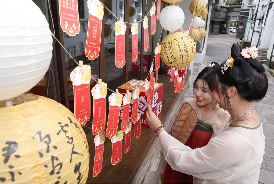 Turistas leen adivinanzas de linternas en el poblado de Qianyuan de la ciudad de Huzhou, provincia oriental china de Zhejiang, el 17 de septiembre de 2024. (Xinhua/Ni Lifang)