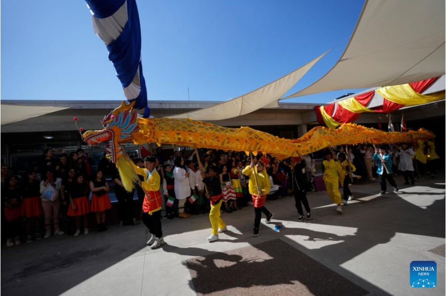 Imagen del 26 de septiembre de 2024 de estudiantes realizando una presentación de la danza del dragón durante el 20° aniversario de la denominación como República Popular China de una escuela primaria estatal en el barrio Casavalle, en Montevideo, capital de Uruguay. Con coloridas danzas y presentaciones musicales, cientos de niños uruguayos celebraron el 20° aniversario de la denominación como República Popular China de una escuela primaria estatal de Montevideo, que tiene el apoyo de la Embajada china. (Xinhua/Nicolás Celaya)