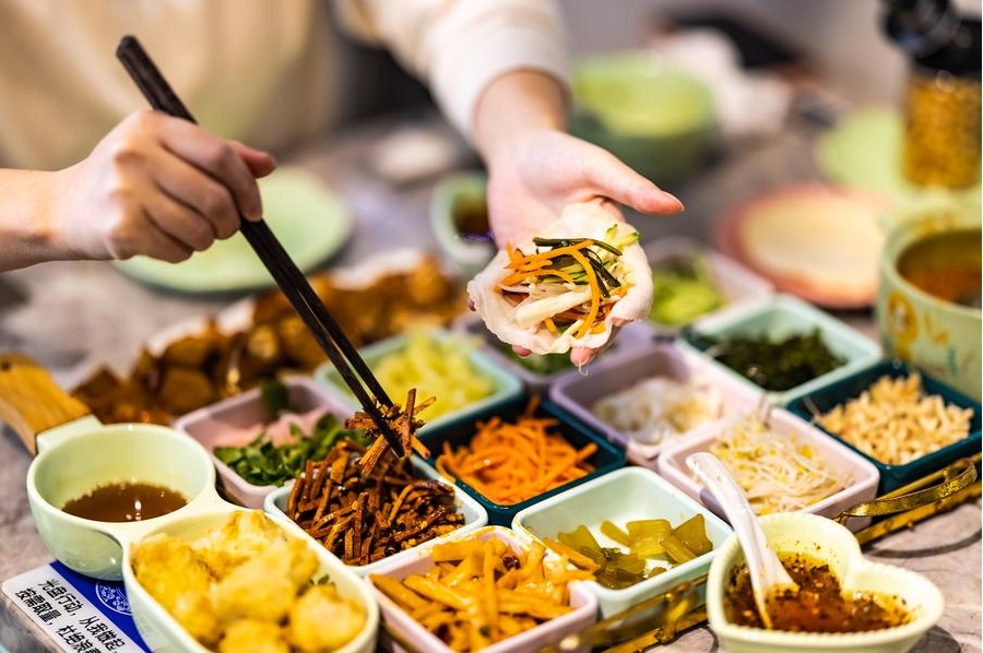 Una persona disfruta de una deliciosa comida en un restaurante del distrito Xixiu de la ciudad de Anshun, en la provincia suroccidental china de Guizhou, el 24 de enero de 2023. (Xinhua/Chenxi)