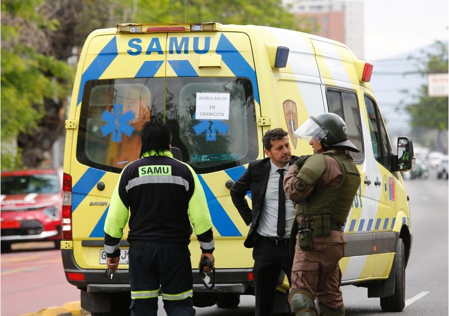 Imagen proveída por la Agencia de Noticias de Chile AGENCIA UNO de miembros de los cuerpos de rescate conversando frente a una ambulancia cerca del sitio de la explosión en el Internado Nacional Barros Arana, en Santiago, capital de Chile, el 23 de octubre de 2024. (Xinhua/Diego Martin/Agencia UNO) 