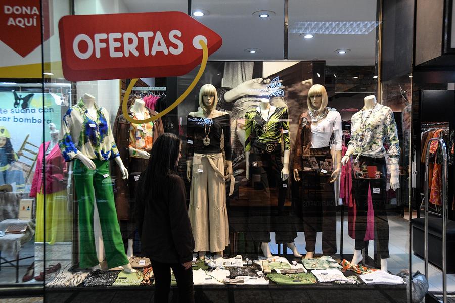 Una mujer observa la ropa exhibida en una tienda, en Santiago, capital de Chile, el 2 de octubre de 2024. (Xinhua/Jorge Villegas)