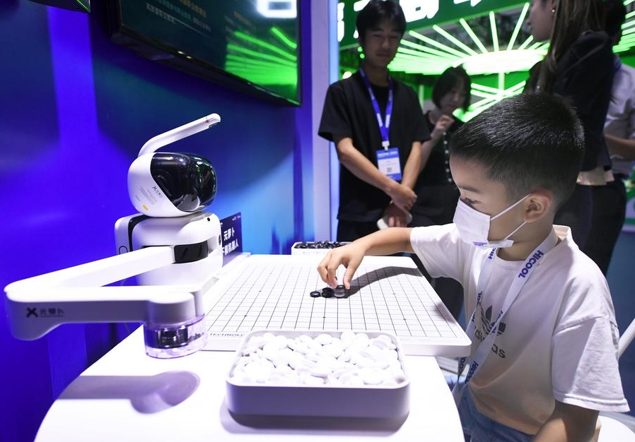 Imagen del 24 de agosto de 2024 de un niño jugando ajedrez con un robot en el área de exposiciones de la Cumbre Global de Emprendedores HICOOL 2024, en Beijing, capital de China. (Xinhua/Ren Chao) 