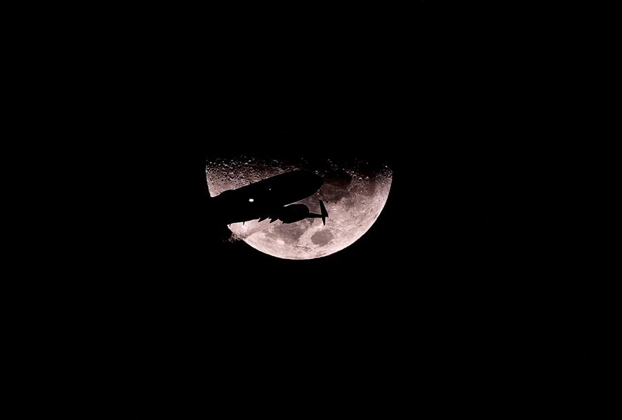 Un avión vuela frente a la Luna previo a iniciar sus maniobras de aterrizaje en el Aeropuerto Internacional de la Ciudad de México, capital de México, en las primeras horas del 10 de enero de 2022. (Xinhua/David de la Paz)