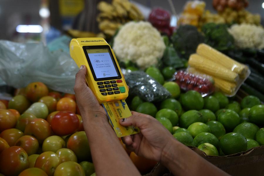 Una mujer paga sus compras con una tarjeta de beneficio social en un mercado, en Brasilia, Brasil, el 18 de mayo de 2024. (Xinhua/ Lucio Tavora) 