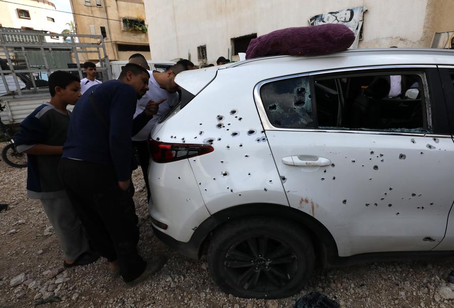 Personas se reúnen en torno a un vehículo dañado en una incursión israelí, en la ciudad cisjordana de Qalqilya, el 12 de diciembre de 2024. (Xinhua/Nidal Eshtayeh) 