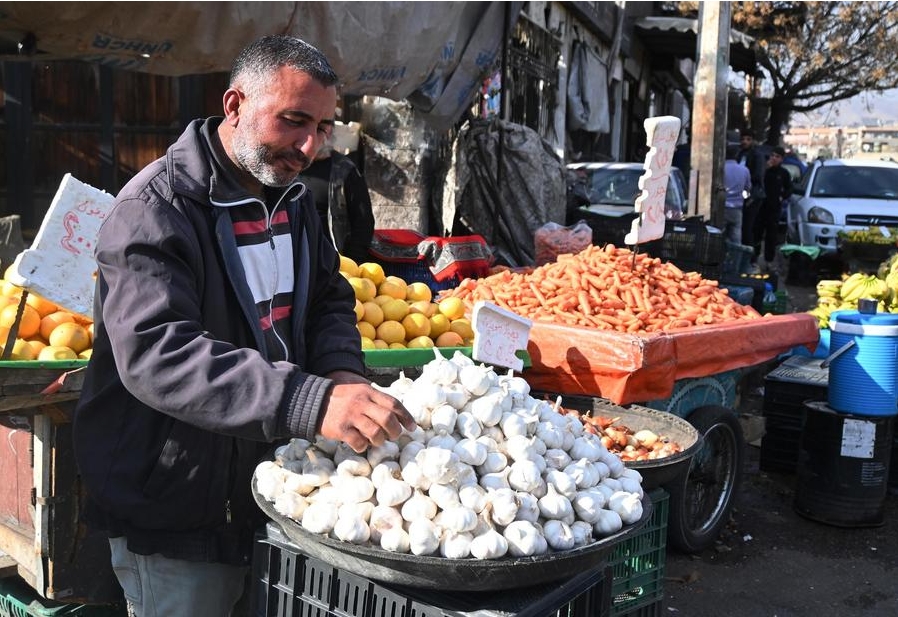 Imagen del 16 de diciembre de 2024 de un vendedor exhibiendo sus productos para la venta a lo largo de una calle en Damasco, Siria. (Xinhua/Ammar Safarjalani)