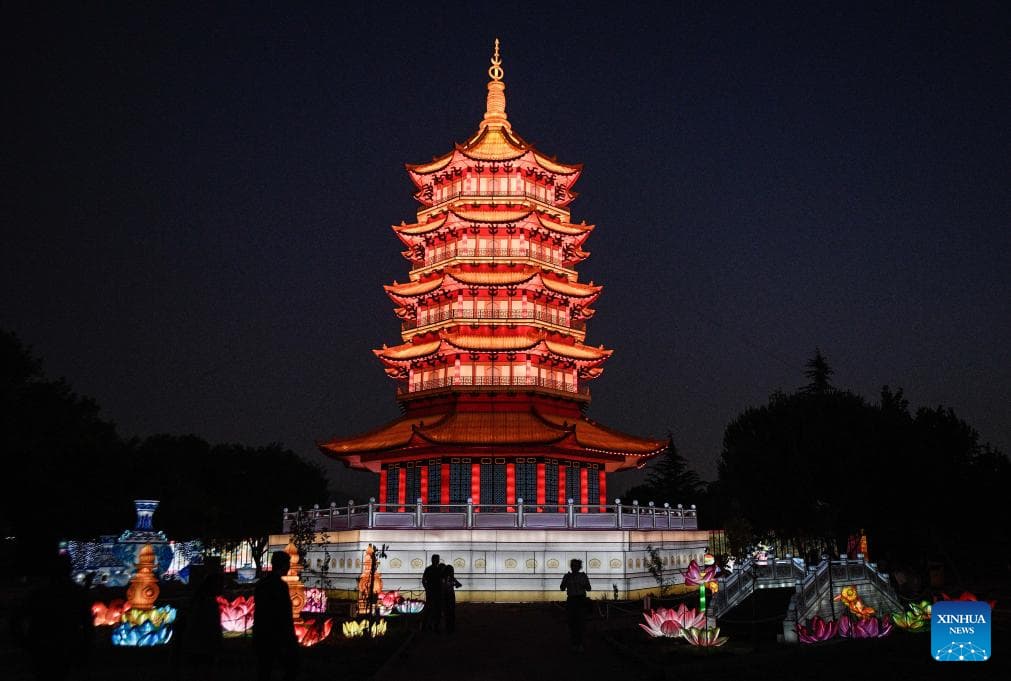 Imagen del 14 de diciembre de 2024 de personas observando esculturas iluminadas durante la feria de luces tradicionales chinas Tianfu Festival en el parque Orione, en Santiago, capital de Chile. El bosque de pandas, el puente de Lanzhou y la representación de la Pagoda Leifeng de 30 metros de altura, son algunas de las atracciones a gran escala que iluminan las noches veraniegas en Chile, en el marco de la feria de luces tradicionales chinas Tianfu Festival. (Xinhua/Jorge Villegas)