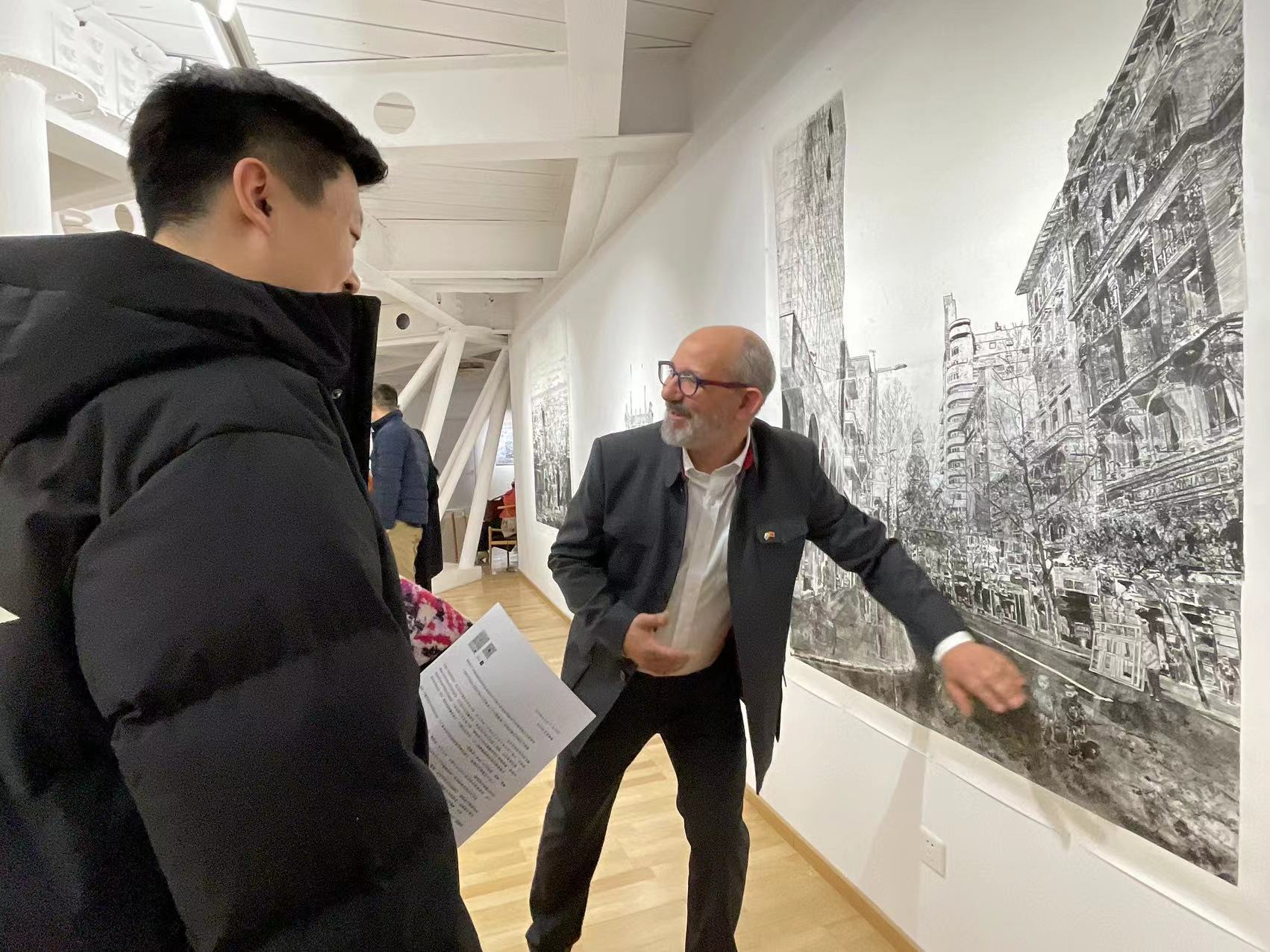 El artista Federico Arnaud dialoga con los asistentes a la inauguración de “Paisaje de los sueños”, exposición personal inaugurada en el Centro de Arte Uruguayo de la Zona Artística 798, Beijing, 19 de diciembre del 2024. (Diario del Pueblo digital/ YAC)