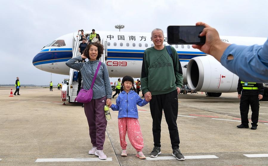 Pasajeros posan para tomarse fotos con el avión C919 tras bajar de la aeronave en el Aeropuerto Internacional Meilan de Haikou, capital de la provincia de Hainan, en el sur de China, el 11 de diciembre de 2024. (Xinhua/Yang Guanyu)