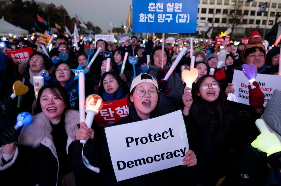 Personas festejan la aprobación de la moción de destitución contra el presidente Yoon Suk-yeol cerca de la Asamblea Nacional, en Seúl, República de Corea, el 14 de diciembre de 2024. (Xinhua/Jun Hyosang)