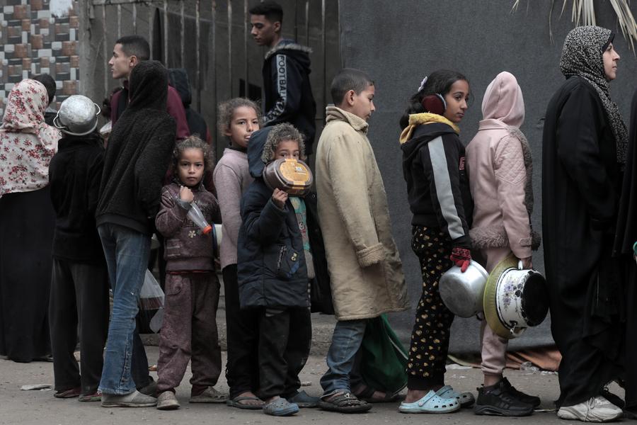 Personas hacen fila para recibir ayuda alimentaria en un centro de distribución de alimentos, en la ciudad de Deir al-Balah, en el centro de la Franja de Gaza, el 20 de diciembre de 2024. (Xinhua/Rizek Abdeljawad) 